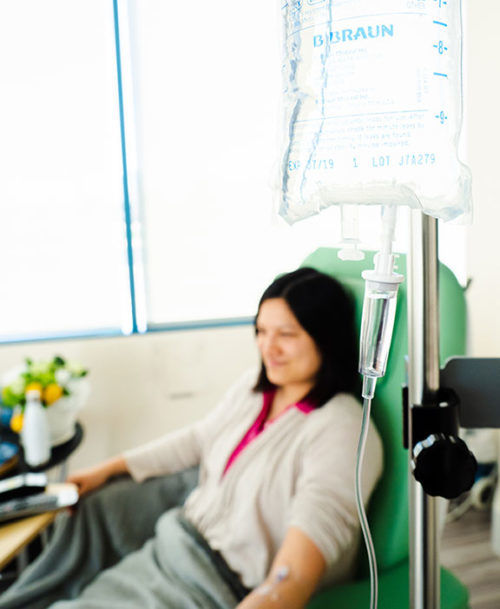 patient sitting in a reclining infusion chair with a iv bag close up