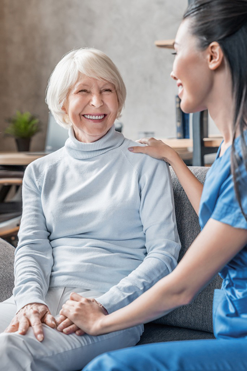 vertical-shot-of-helpful-nurse-taking-care-of-senior-woman