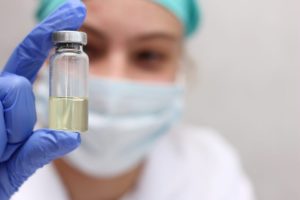 Nurse holding a clear vial