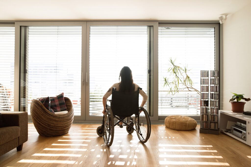 A woman sitting in a wheelchair at home