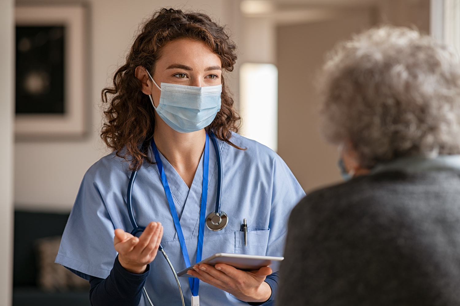 A nurse talking to an elderly woman