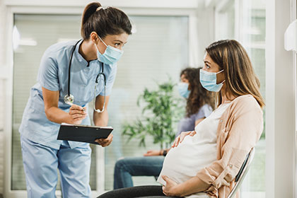 A nurse conversing with a pregnant woman