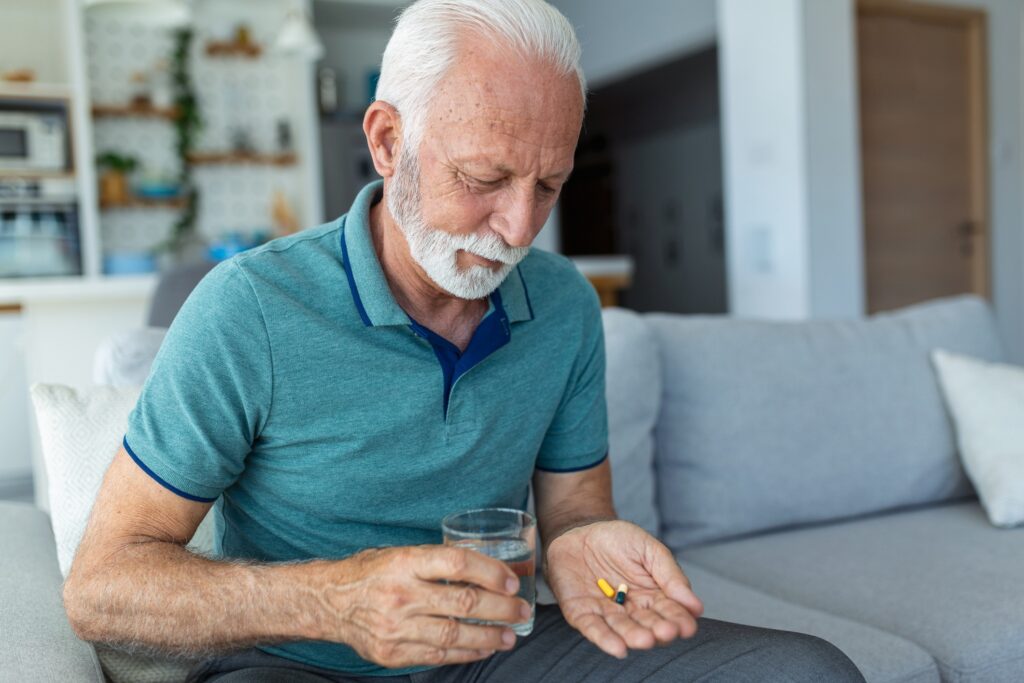 An old man taking medications