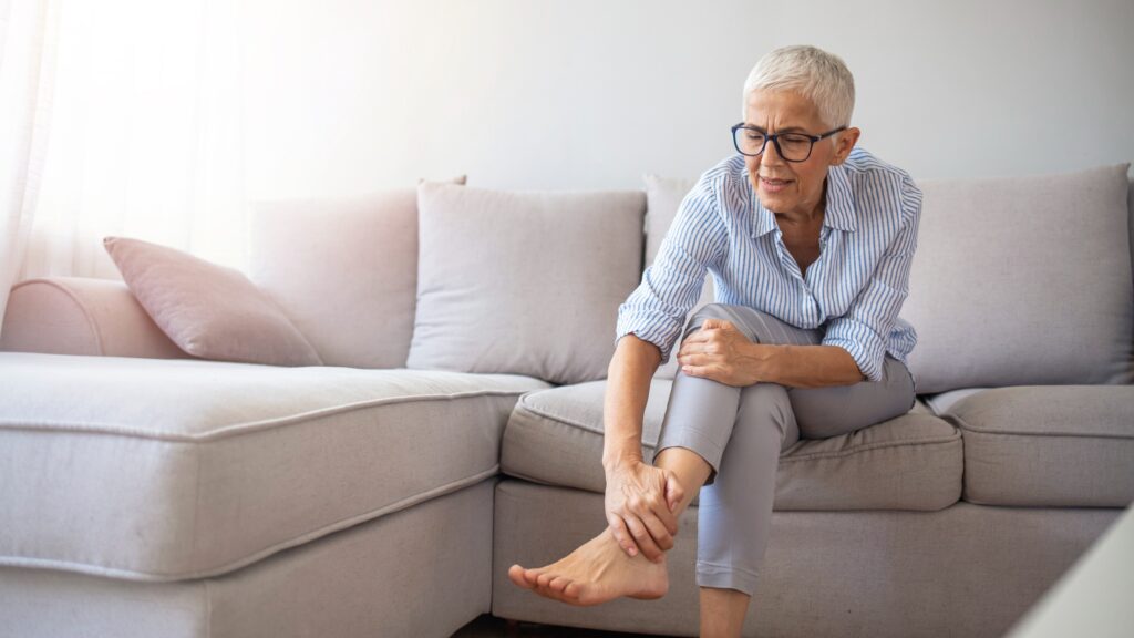 A woman holding her ankle in pain