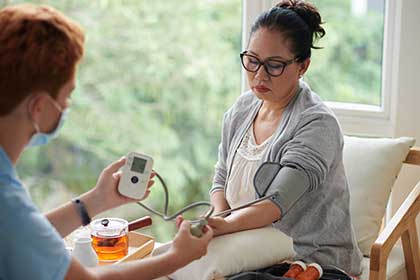 Nurse checking blood pressure of droxidopa patient