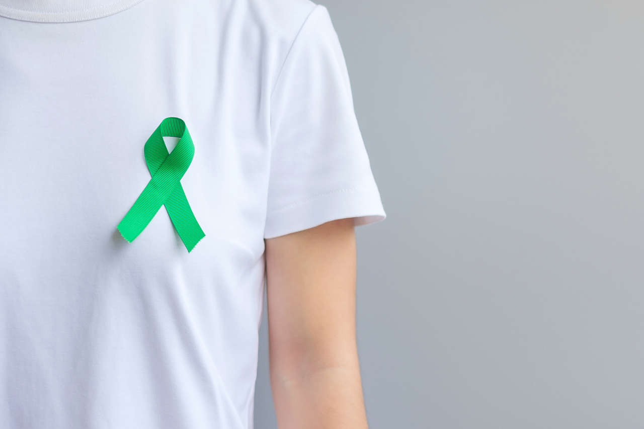 Person wearing green ribbon for lymphoma awareness
