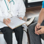 Doctor consulting with plaque psoriasis patient