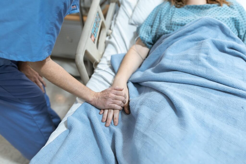 A nurse holding a patient’s hand