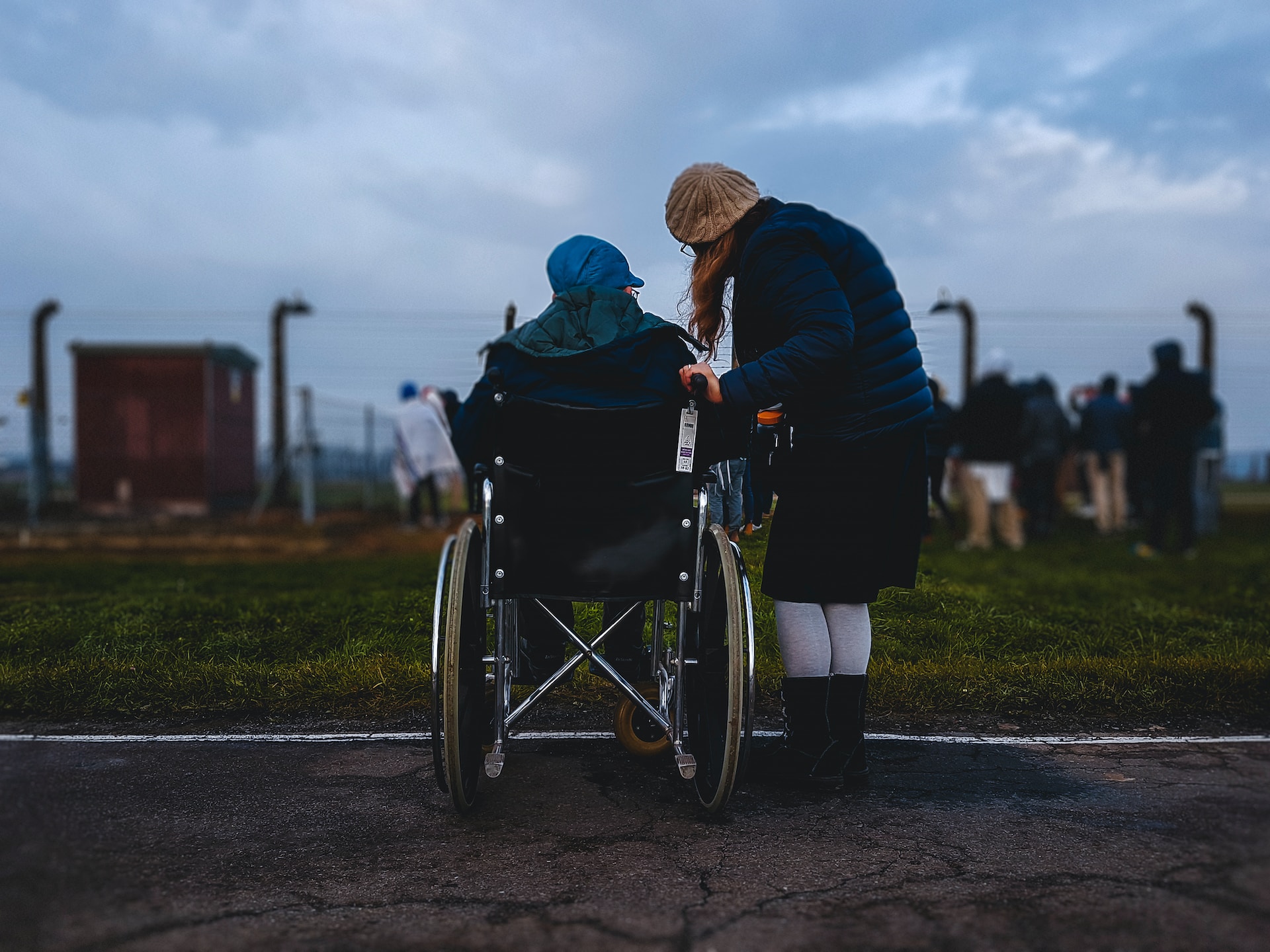 A woman standing next to a person in a wheelchair