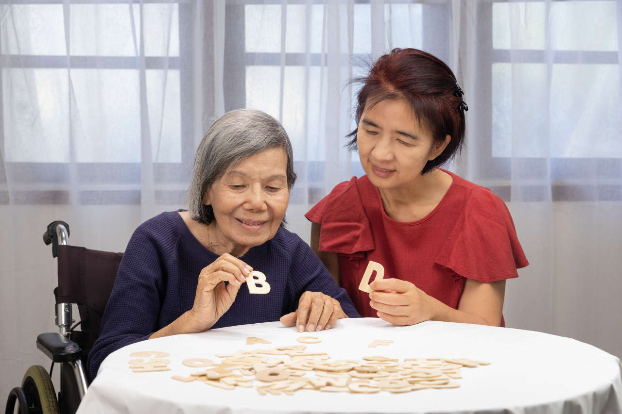 Elderly woman playing alphabet games for improve mental health and memory with daughter