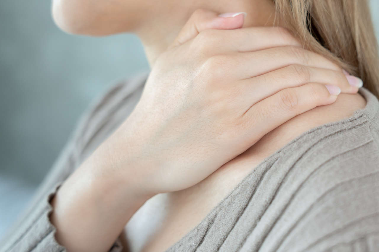 Woman with myositis massaging neck