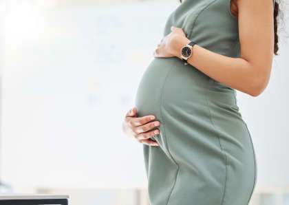 Closeup shot of a pregnant woman standing with hands on stomach