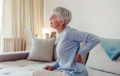 Woman with back pain as a side effect of taking Kisqali