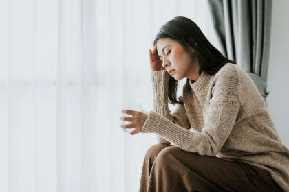 Woman feeling headache from IVIG withdrawal