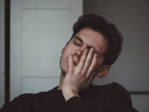 Man touching his face, representing symptoms of autoimmune encephalitis.