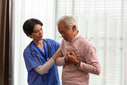 Nurse with man suffering chest pain from plasmapheresis