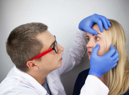 An ophthalmologist examines a woman's eyes