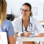 Female doctor explaining myasthenia gravis risk factors to patient
