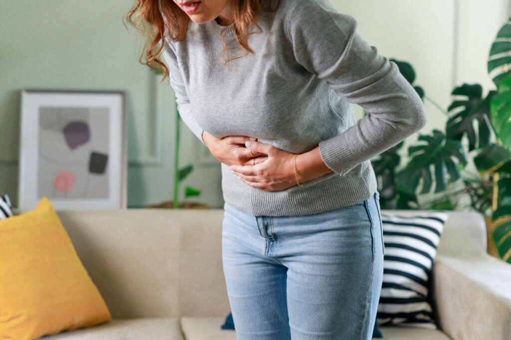 A woman holding her stomach in pain