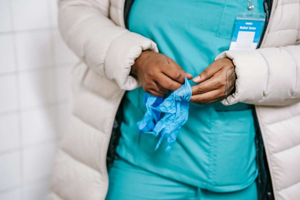 A female nurse putting on gloves