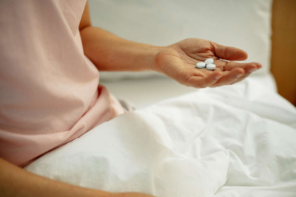 A person holding a handful of pills