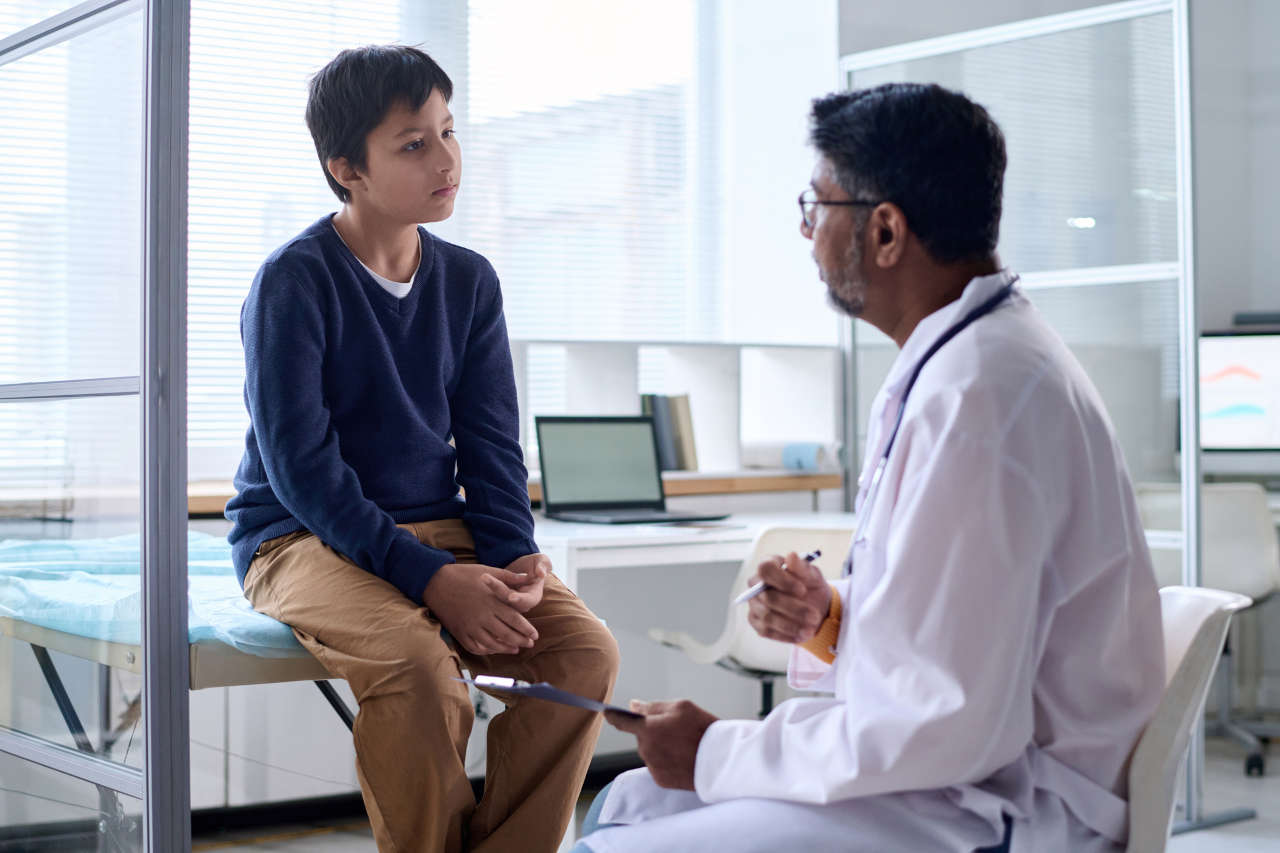 Doctor talking to young boy and Nuwiq