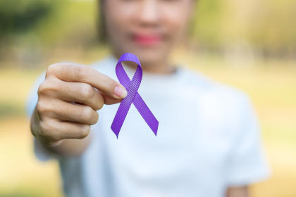 Woman holding purple ribbon for lupus awareness