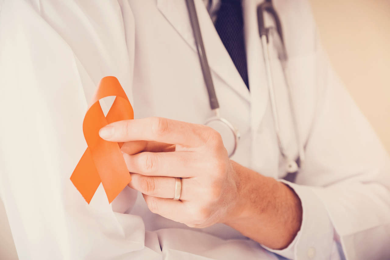 Doctor holding orange ribbon for multiple sclerosis awareness