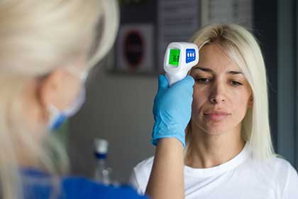 A nurse checking a patient’s fever