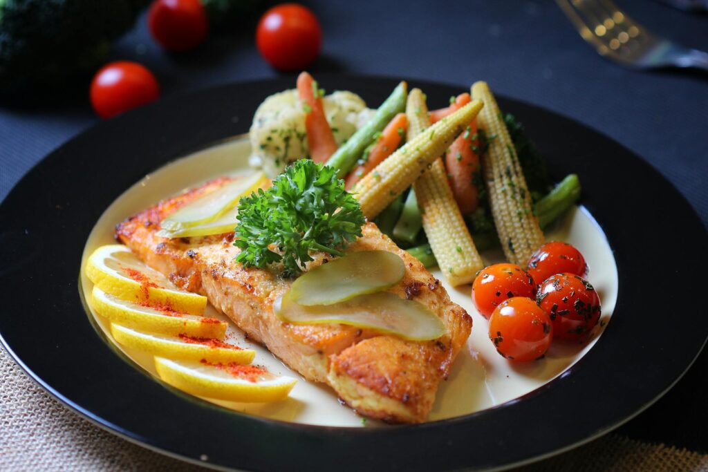 A plate with fish and cooked vegetables 
