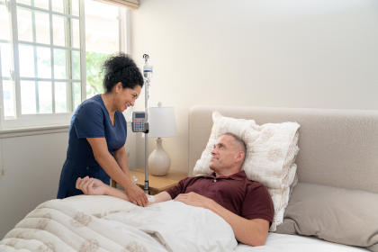 Man on bed receiving IVIG therapy at home