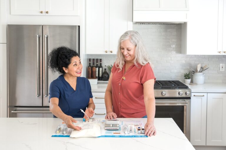 A smiling nurse preparing TPN supplies on a kitchen countertop