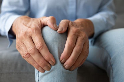A patient holding his knee in pain