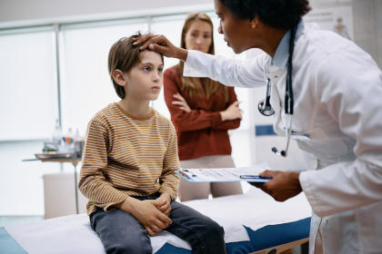 Doctor meeting with child who has a headache as a side effect of IVIG