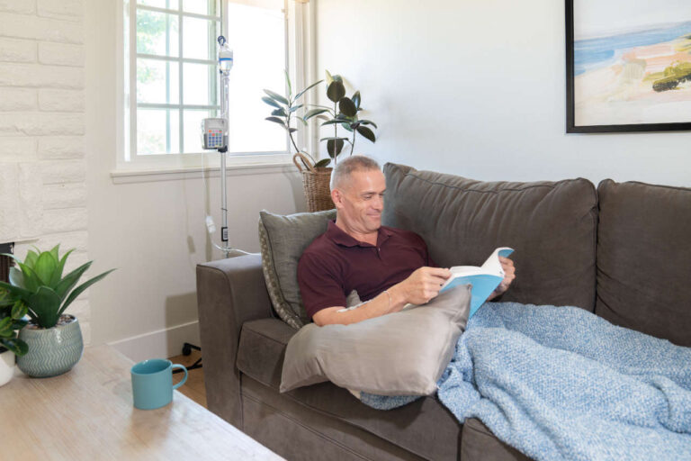 Man on sofa receiving Ig therapy at home