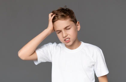 A child holding his head in pain