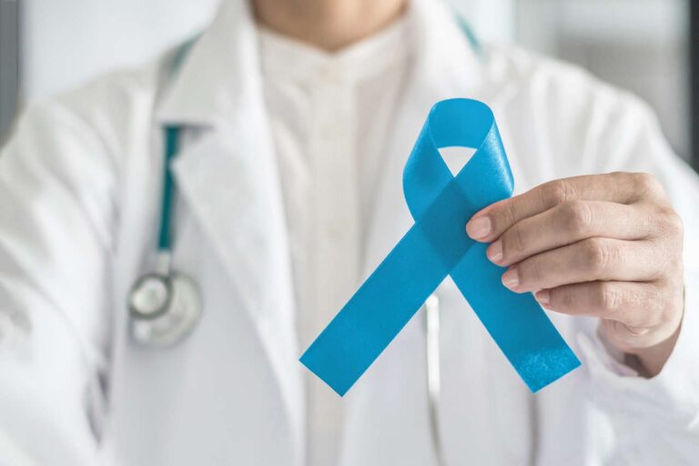 A doctor holding up a blue ribbon