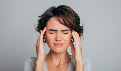 Woman experiencing headache as a result of taking Wilate