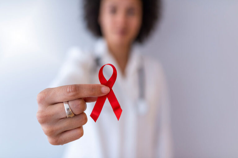 A doctor holding a red hemophilia awareness ribbon