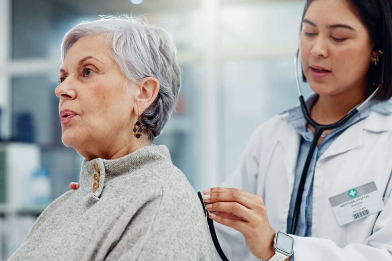 A doctor checking a patient’s breathing with a stethoscope