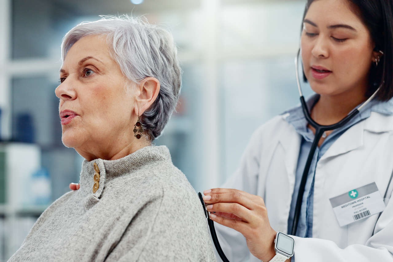 A doctor checking a patient’s breathing with a stethoscope