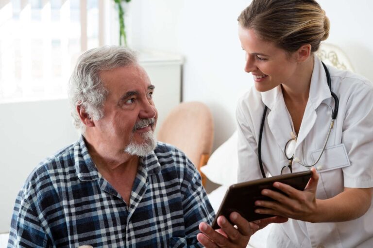 A smiling doctor explaining something to an elderly patient