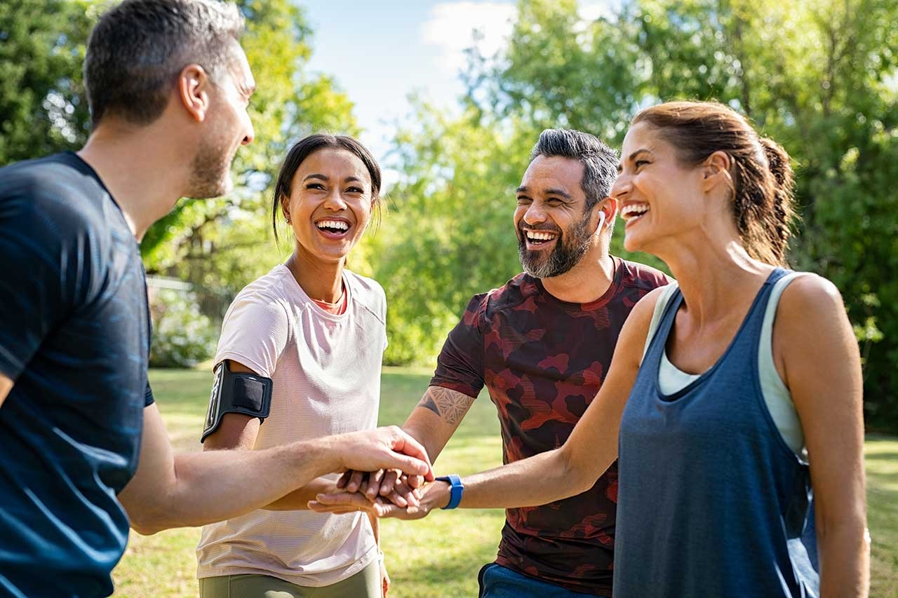 A group of people laughing and stacking their hands