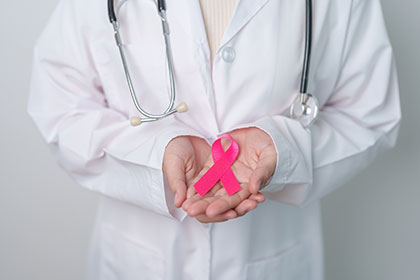 Doctor holding pink ribbon for breast cancer awareness
