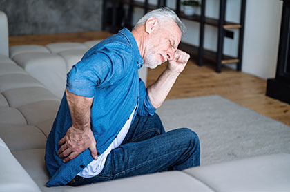Man suffering from back pain as a side effect of taking Ninlaro
