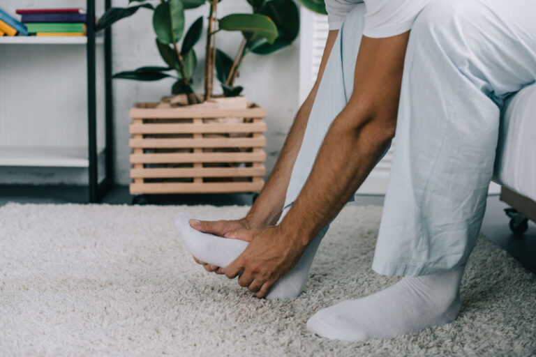 A man with SFN holding his foot in pain