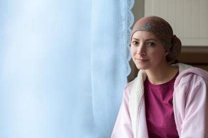 Smiling cancer patient sitting and resting at home