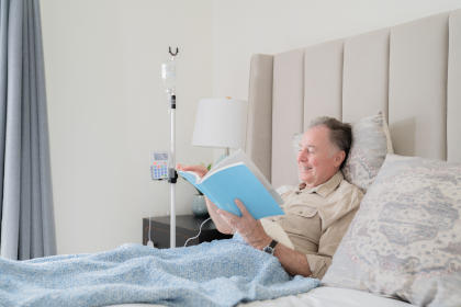 Patient receiving IVIG at home while reading a book