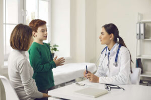 El médico consulta con el niño y su madre sobre el Jivi.