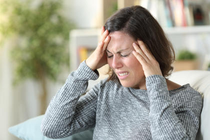 Patient experiencing headache, a symptom of vasculitis